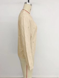 Detail of beige long sleeve knit sweater showing delicate pointelle diamond patterns