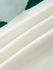 Close-up of color-block knit sweater texture with white, light blue and green stripes