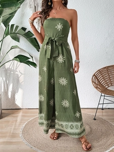 Detail of green strapless wide-leg jumpsuit with white mandala print and tie-waist belt