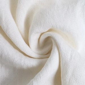 Dettaglio ravvicinato del tessuto bianco a pieghe con texture elegante e caduta morbida