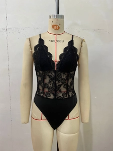 Detail of black lace bodysuit with semi-transparent waist and delicate floral patterns