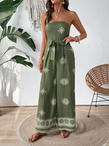 Detail of dark green strapless jumpsuit with ethnic prints and tied waist bow belt