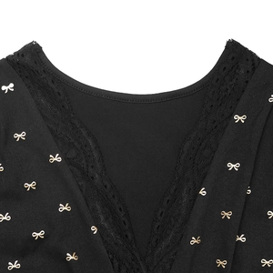 Détail de l'encolure en V avec dentelle noire et motifs de petits nœuds dorés
