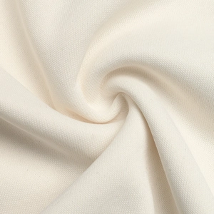 Macro texture of cream white thick knit cotton fabric with soft diagonal twill structure