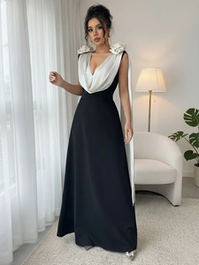Detailed view of deep V-neck white satin top with 3D floral accents on a black maxi dress