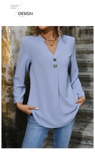 Detail of light blue elegant long-sleeve blouse with V-neckline and decorative dark buttons