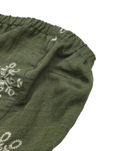 Detail of elastic waist on dark green cotton jumpsuit with white ethnic star embroidery