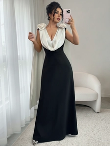 Detail of elegant V-neck gown with white floral shoulder accents and contrast sleeves