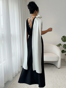 Elegant sleeveless black evening gown with white shoulder drapes and tied back detail