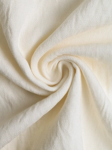 Detailed macro view showing the cream-colored cotton linen fabric texture and soft weave