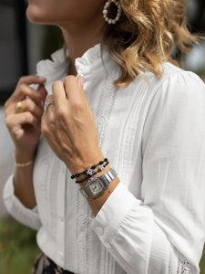 Detail of white lace long sleeve shirt with stand collar and intricate ruffle splicing