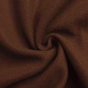 Dettaglio ravvicinato della texture in lana marrone scuro, morbida e spessa dei tessuti