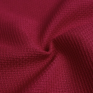 Gros plan sur le tissu tissé bordeaux avec texture de fibre pour les robes élégantes