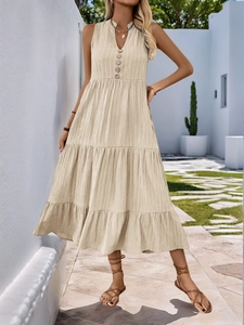 Detail of V-neckline with wooden buttons on a tiered beige summer maxi dress