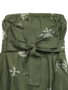 Close-up of green linen jumpsuit fabric featuring white floral embroidery and a bow waist tie