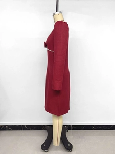 Détail de l'élégante encolure en perles et de la décoration de nœud chic sur la robe bordeaux