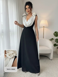 Close-up of elegant V-neckline with large white 3D floral accents on a black evening gown