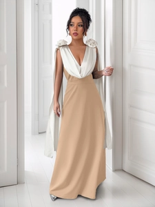 Detail of elegant V-neck gown featuring white 3D fabric roses and a flowing shoulder cape