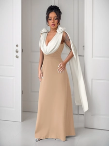 Detail of elegant V-neck gown featuring contrast white shawl and 3D floral accents