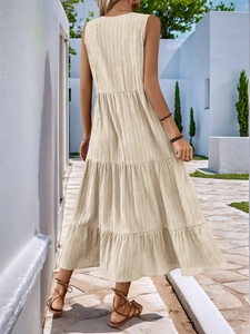 Detail of beige sleeveless tiered maxi dress featuring a textured fabric and open back design