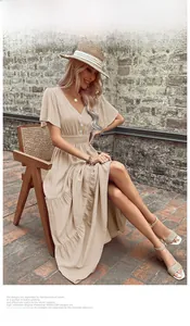 Dettagli dell'elegante abito beige con scollo a V, bottoni decorativi e maniche a volant