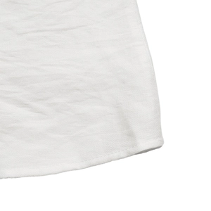 Detailed macro view of white fabric hem with clean stitching and refined texture