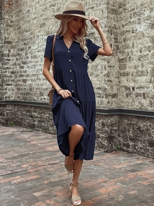 Detail shot of the navy short sleeve shirt dress with wooden buttons and a tiered skirt
