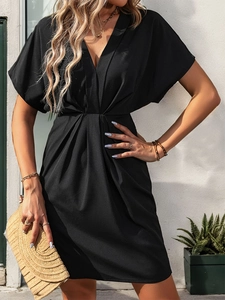 Détail d'une robe d'été noire à col en V avec manches chauve-souris et taille plissée