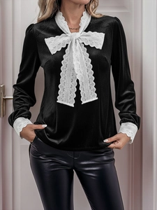 Detail of the elegant white lace bow and vintage velvet texture on a black long sleeve shirt