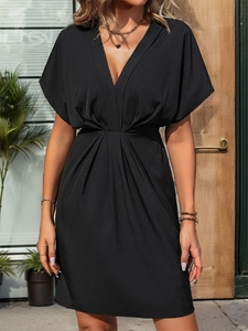 Détail de robe noire à col en V avec taille plissée élégante et tissu fluide de qualité