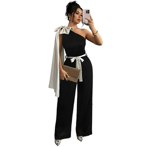 Combinaison noire asymétrique avec nœud contrasté et pantalon large à taille haute
