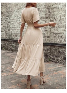 Dettaglio dell'elegante abito midi beige con vita alta a punto smock e gonna a balze