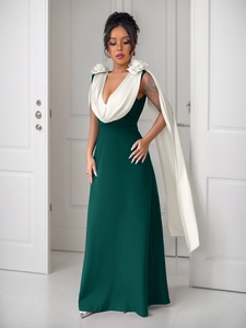 Detailed close-up of dark green V-neck evening gown with white floral shoulder accents