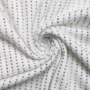 Détail macro du tissu en maille blanche avec des motifs de strass argentés verticaux