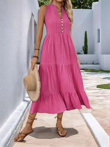 Detail of rose pink V-neck tiered maxi dress featuring textured fabric and wooden buttons