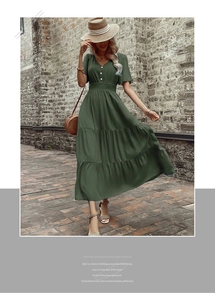 Dettaglio del vestito con scollo a V, bottoni bianchi e gonna a balze in verde scuro