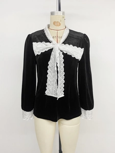 Detail showing the intricate white lace collar and bow on a black velvet shirt