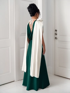 Detail of elegant dark green satin gown with white shawl and open back design