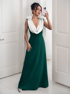 Detail of dark green evening dress with large 3D white floral shoulders and silk V-neckline