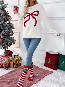 Detail of white knit sweater with red bow pattern and contrast stitching for Christmas