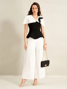 Détail d'un chemisier patchwork noir et blanc élégant et d'un pantalon large à taille haute
