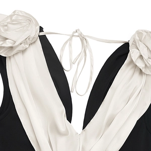 Detailed view of elegant deep V-neckline with 3D white satin rose floral shoulder decor
