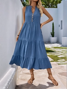 Detail of blue tiered sleeveless dress with pleated fabric and small V-neck with wooden buttons