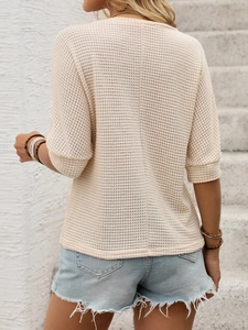Détail du haut en maille gaufrée beige avec couture arrière et short en jean à bords crus