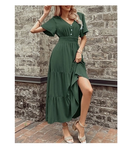 Dettaglio dell'abito verde scuro con scollo a V, gonna a strati e maniche a volant