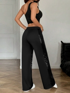 Detailed view of women's black high-waisted wide-leg trousers with side sequin stripes