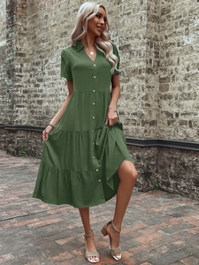 Detail of dark green tiered midi dress featuring short sleeves and classic button closure