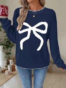 Detail of navy blue knit sweater featuring a white bow pattern and ribbed cuffs for winter