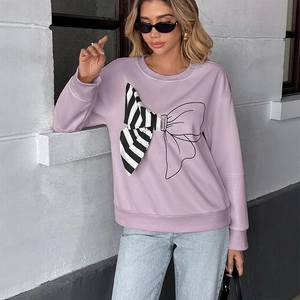 Detail of lavender loose sweatshirt featuring a unique mixed-pattern bow graphic on front