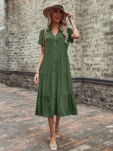 Detail of a dark green short-sleeved dress with a layered tiered skirt and button-down front